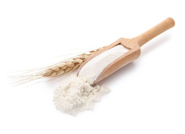 Beyaz arka planda tahtadan un ve buğday kulaklı kepçe.