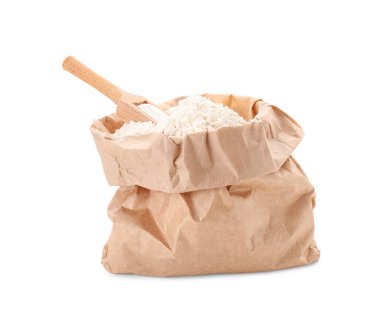 Beyaz arka planda tahtadan kepçe ve buğday unlu kağıt torba.