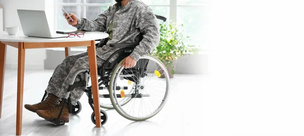 Soldier in wheelchair working at home. Banner for design