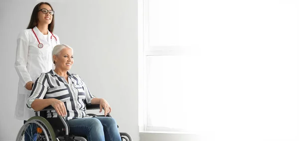 Dojrzała Kobieta Wózku Inwalidzkim Młodym Lekarzem Klinice Baner Projektowania — Zdjęcie stockowe