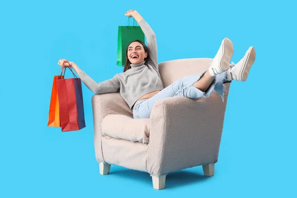 Young Woman Shopping Bags Sitting Soft Armchair Blue Background — Stock Photo, Image