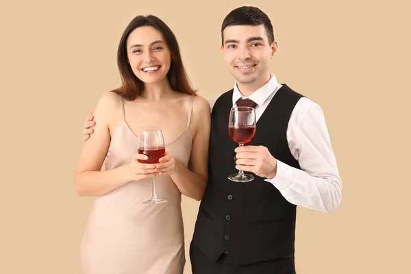 Elegantes Junges Paar Mit Weingläsern Auf Beigem Hintergrund — Stockfoto