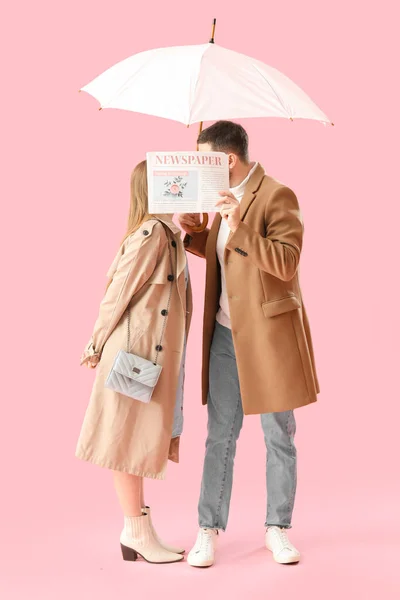 Young Couple Umbrella Kissing Newspaper Pink Background — Stock Photo, Image
