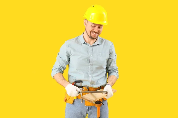Mężczyzna Stolarz Ostrzenie Drewniane Deska Pliku Żółtym Tle — Zdjęcie stockowe