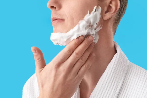 Jovem Aplicando Espuma Barbear Rosto Contra Fundo Azul Claro Close — Fotografia de Stock