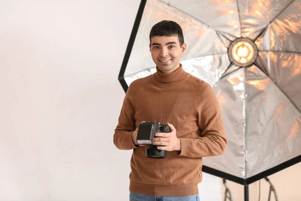 在演播室里带专业相机的年轻男性摄影师 — 图库照片