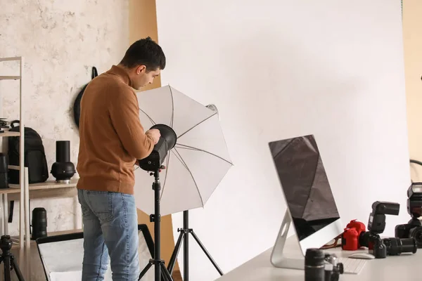 スタジオでのプロ仕様の機器を持つ若い男性写真家 — ストック写真