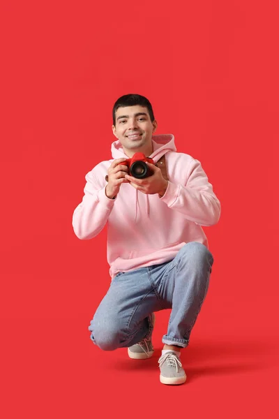 Joven Fotógrafo Masculino Con Cámara Profesional Sobre Fondo Rojo — Foto de Stock