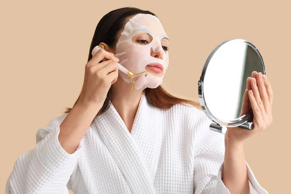 Ung Kvinna Med Sheet Mask Ansiktsmassage Verktyg Och Spegel Beige — Stockfoto