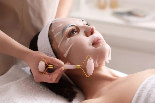 Kosmetolog Massera Kvinnans Ansikte Med Sheet Mask Salong Närbild — Stockfoto