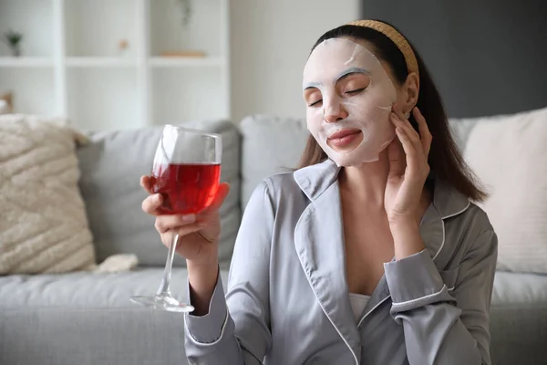 Ung Kvinna Med Sheet Mask Och Glas Vin Hemma — Stockfoto