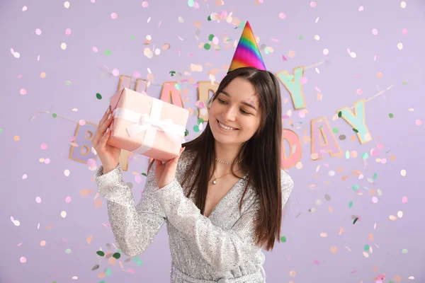 Glückliche Junge Frau Mit Geschenk Feiert Geburtstag Auf Fliederfarbenem Hintergrund — Stockfoto