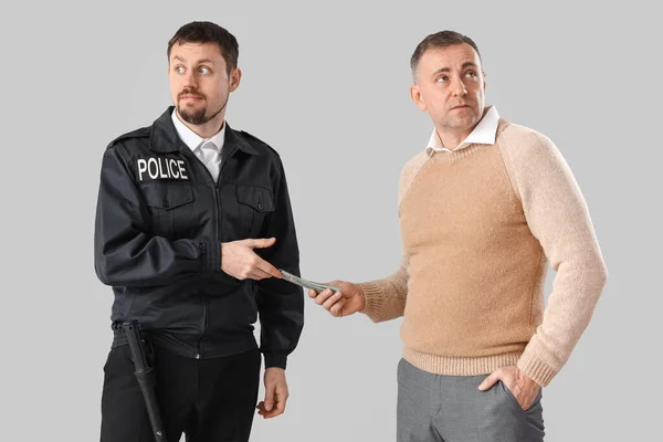 Mature Man Giving Bribe Policeman Grey Background — Stock Photo, Image