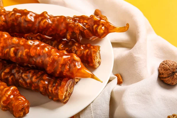 stock image Plate with tasty churchkhela on yellow background, closeup