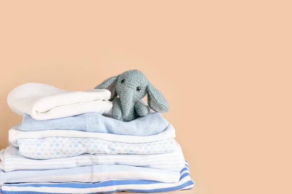 Stapel Verschiedener Babykleidung Und Lustiges Spielzeug Auf Farbigem Hintergrund — Stockfoto