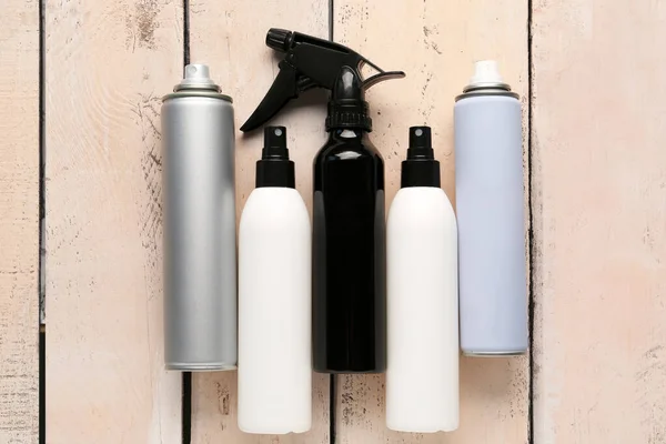 Different Bottles Hair Sprays Light Wooden Background — Stock Photo, Image