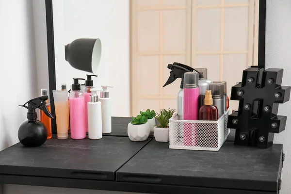 Different sprays and hair care products on table in beauty salon