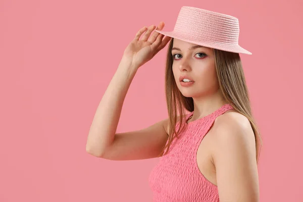 穿着粉色背景帽子的时髦年轻女人 — 图库照片