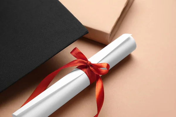 Kırmızı Kurdeleli Diploma Mezuniyet Şapkası Kahverengi Arka Plan Kitabı — Stok fotoğraf
