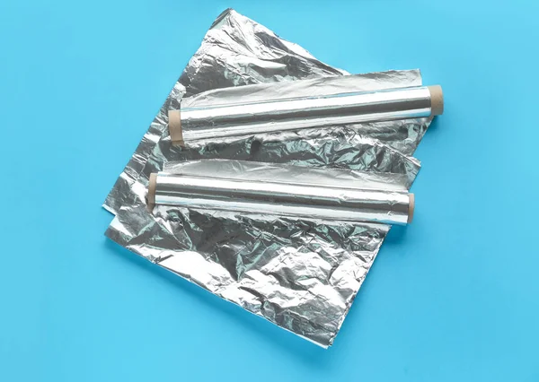 stock image Aluminium foil rolls and sheet on color background