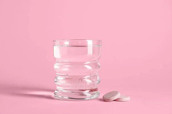 Vaso Agua Con Tabletas Solubles Sobre Fondo Rosa —  Fotos de Stock