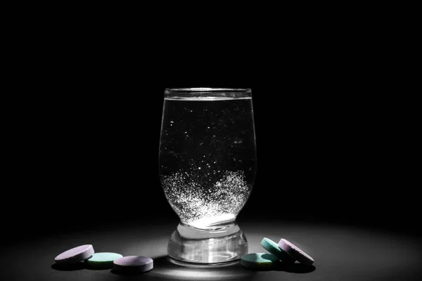 暗い背景に水溶性の錠剤と水のガラス — ストック写真