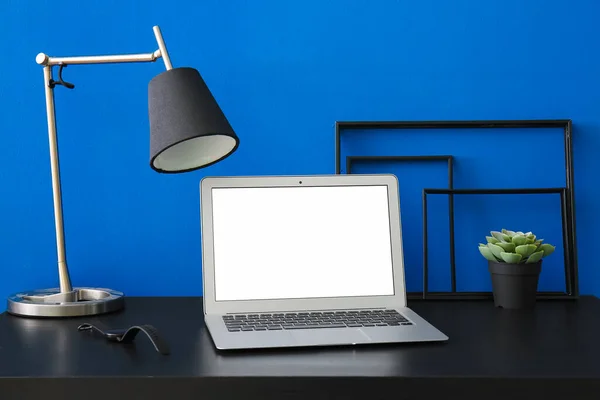 Arbetsplats Med Laptop Lampa Och Blomkruka Nära Blå Vägg — Stockfoto