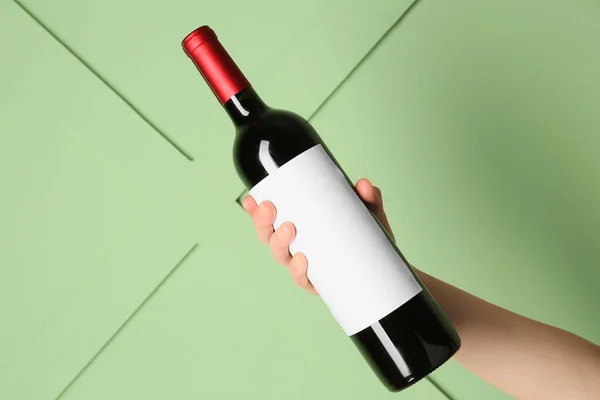 Female Hand Holding Bottle Red Wine Green Background — Stock Photo, Image