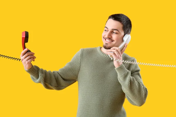 Young Man Talking Two Telephones Yellow Background — Stock Photo, Image