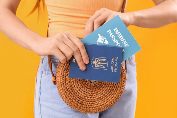 Woman Putting Ukrainian Immune Passports Bag Yellow Background Closeup — Stock Photo, Image