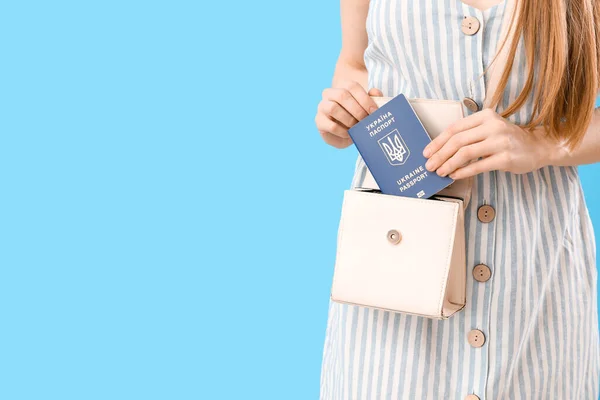 Woman Putting Ukrainian Passport Bag Blue Background Closeup — Stock Photo, Image
