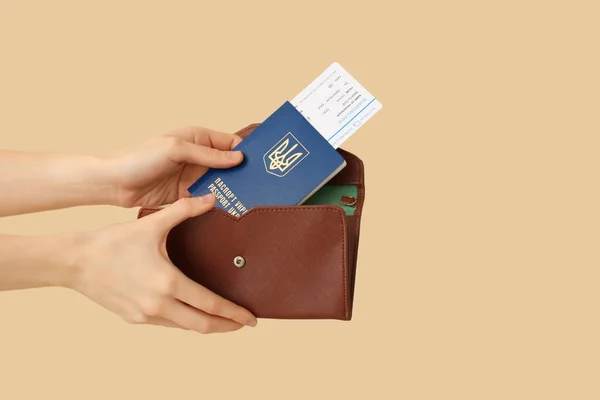 女人把乌克兰护照和车票放在皮夹里 背景是米黄色的 — 图库照片