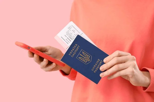 持乌克兰护照 机票和粉色背景手机的妇女 特写镜头 — 图库照片