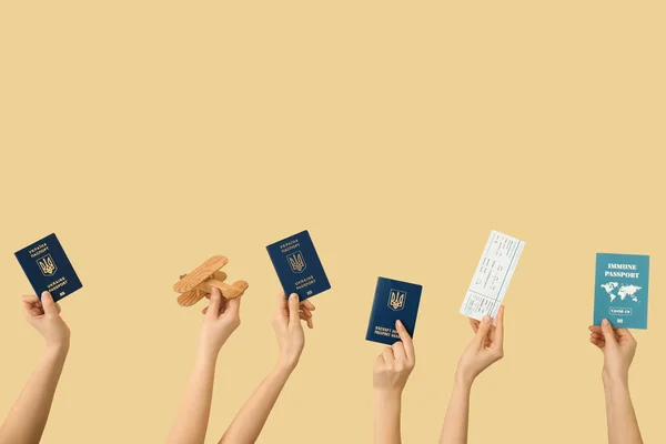 Women Holding Ukrainian Immune Passports Wooden Airplane Ticket Beige Background — Stock Photo, Image