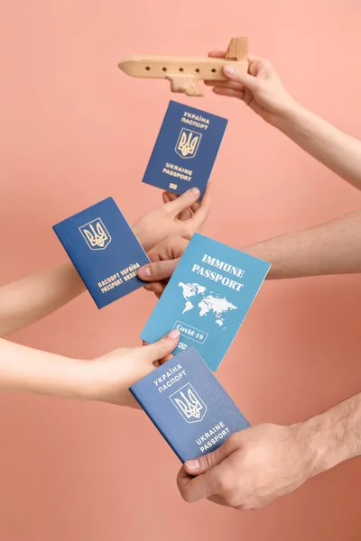 Women Holding Ukrainian Immune Passports Wooden Airplane Pink Background — Stock Photo, Image