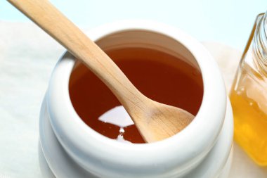 Beyaz arka planda tatlı ballı kavanoz, yakın plan.