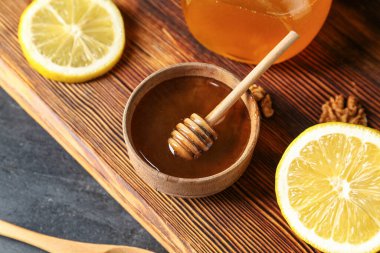 Bir kase tatlı bal ve masada limon.