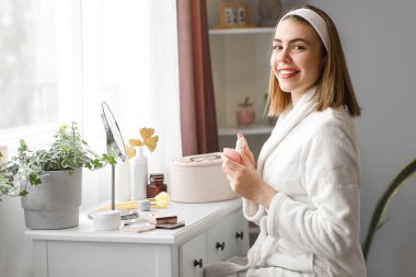 Makyaj vakfını evdeki süngere süren genç bir kadın.