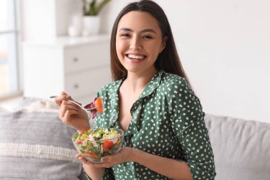 Genç kadın evde sebze salatası yemek