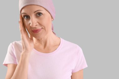 Gri arka planda kemoterapiden sonra olgun kadın, yakın plan.