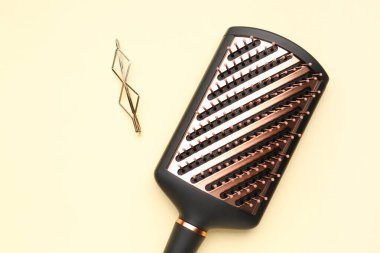 Bej arkaplanda fırçalı saç tokası, yakın plan.