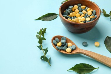 Haplı kase, kaşıklı ve yapraklı mavi arka plan, yakın plan