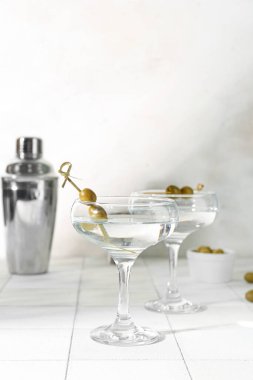 Bardaklar dolusu lezzetli martini ve beyaz fayanslı zeytin.