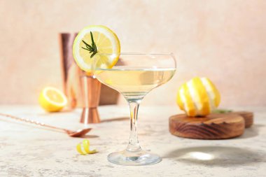 Hafif arkaplanda bir bardak martini ve limon.