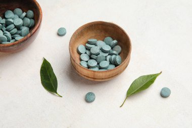 Beyaz arka planda haplar ve yapraklarla dolu kaseler