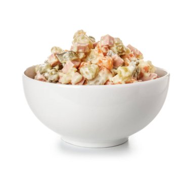 Beyaz arka planda bir kase lezzetli Olivier salatası.