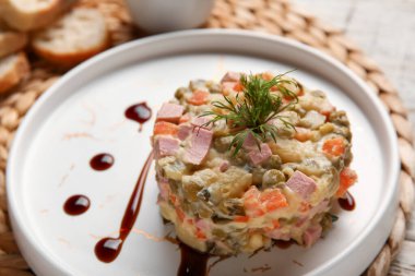 Tabak dolusu lezzetli Olivier salatası masada, yakın plan.