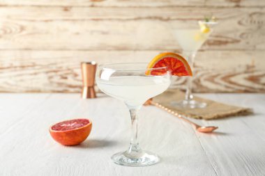 Beyaz ahşap masada greyfurtlu bir bardak martini.