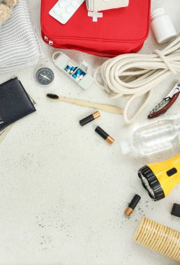 Beyaz masadaki acil durum çantası için gerekli malzemelerden yapılmış çerçeve