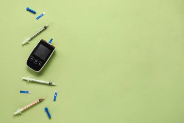 Yeşil zemin üzerinde şeritler ve şırıngalar olan glukometre. Diyabet kavramı